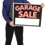 man holding garage sale sign