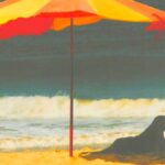 dog on the beach in the shade of an umbrella