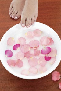 feet dipping into rose petal water