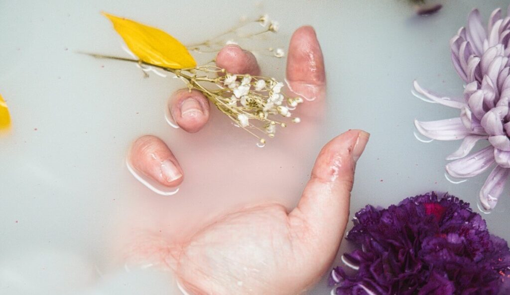 hand soaking in soapy water