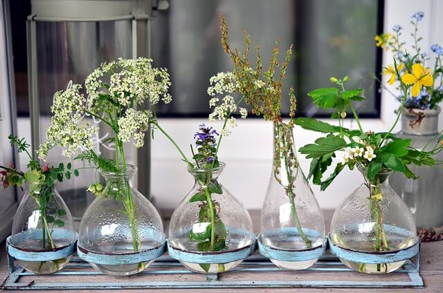 meadow flowers in a row of glass vases