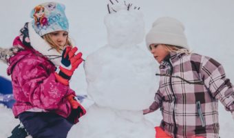 two girls building a snowman